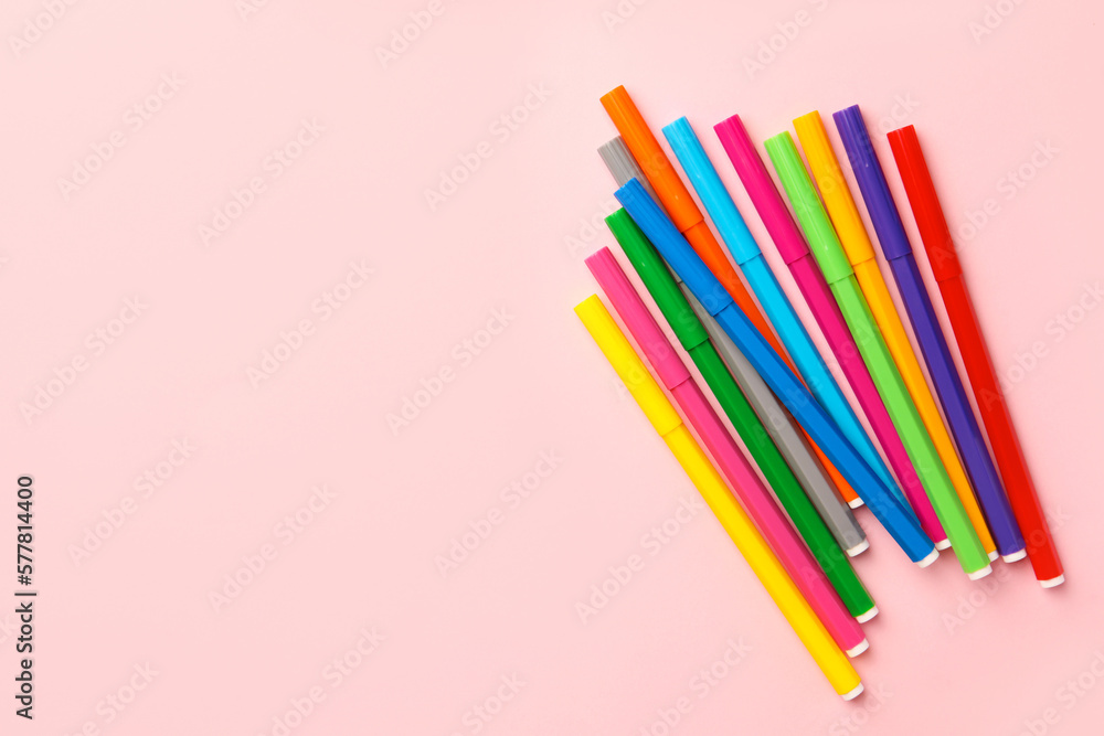 Many bright markers on pink background, flat lay. Space for text Many bright markers on pink background, flat lay. Space for text