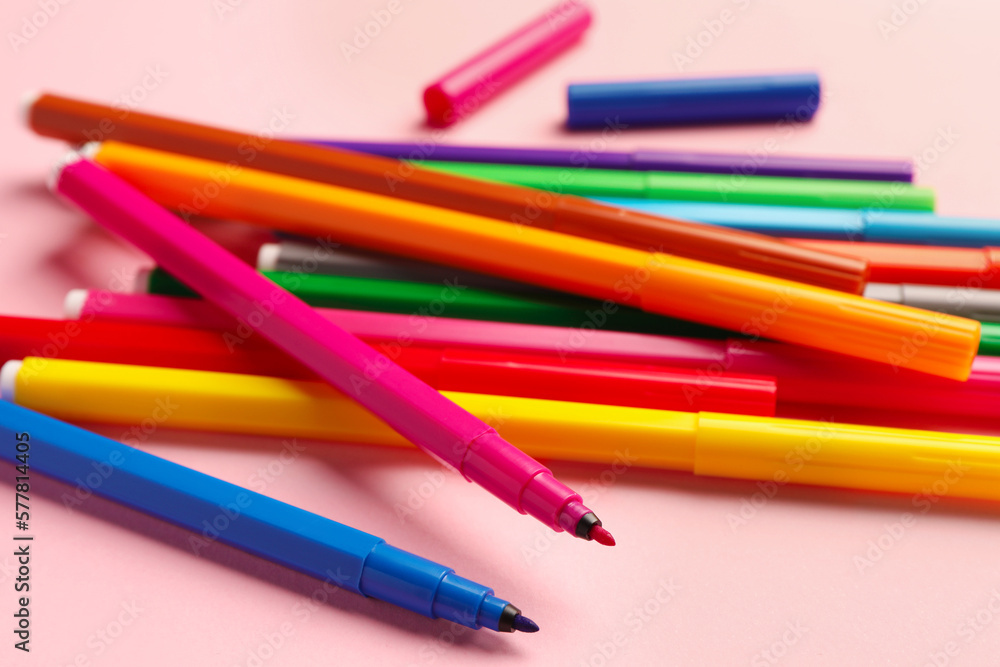 Many bright markers on pink background, closeup Many bright markers on pink background, closeup