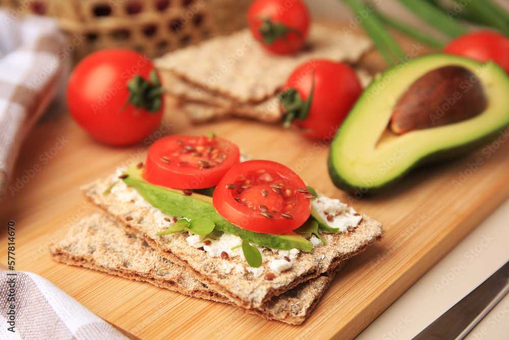 Tasty crispbreads with cream cheese, fresh tomatoes and avocado on beige table, closeup. Space for text Tasty crispbreads with cream cheese, fresh tomatoes and avocado on beige table, closeup. Space for text