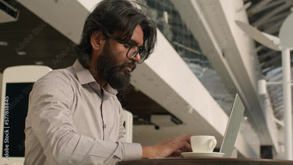Pensive Indian businessman typing on laptop remote working internet concentrated arabian man manager analyzing digital data create business plan using computer app indoors send email in social network Pensive Indian businessman typing on laptop remote working internet concentrated arabian man manager analyzing digital data create business plan using computer app indoors send email in social network