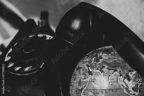 Old telephone and globe in Ukrainian language close up, black and white photo