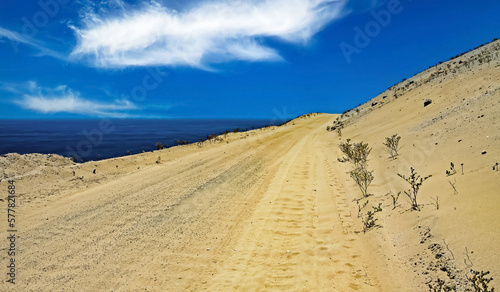 Empty sandy road track directly at water for 4x4 car trips on the sea coast along sand dunes - Pan de Azucar  Chile