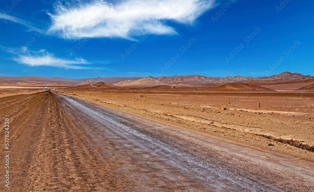Endless eternally long empty straight desert road, red monotonous vegetationless life hostile flat dry barren arid landscape - Salar de Atacama, Chile