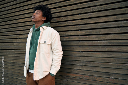 Photo Cool young hipster gen z African American teen standing at wooden wall