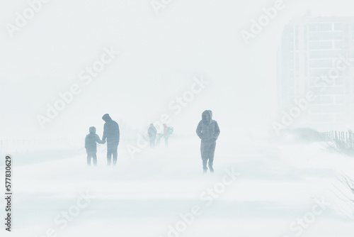 A snowstorm in the city. People are walking down the street during a snowstorm. Strong wind and snowfall. Arctic climate..