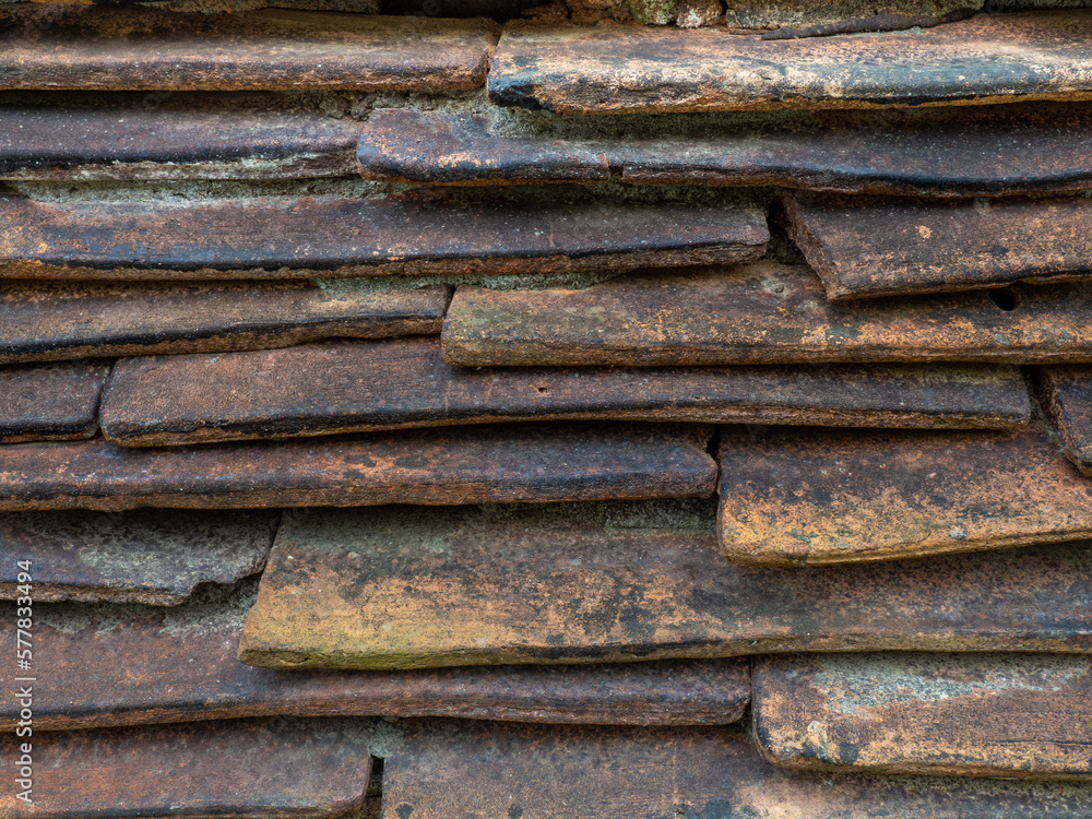 Background from the old tiled masonry. Orange tiles. Wall made of clay fragments. Wall texture. Background from the old tiled masonry. Orange tiles. Wall made of clay fragments. Wall texture.