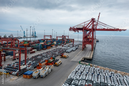 Slika na platnu Various containers and cars waiting to be loaded onto the ship at the port