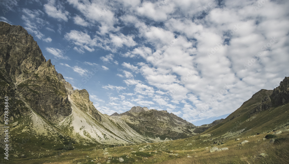 Mountain landscape with rocky peaks, slopes, hills and valleys with vegetation, in the early morning in the mountains with beautiful clouds Mountain landscape with rocky peaks, slopes, hills and valleys with vegetation, in the early morning in the mountains with beautiful clouds