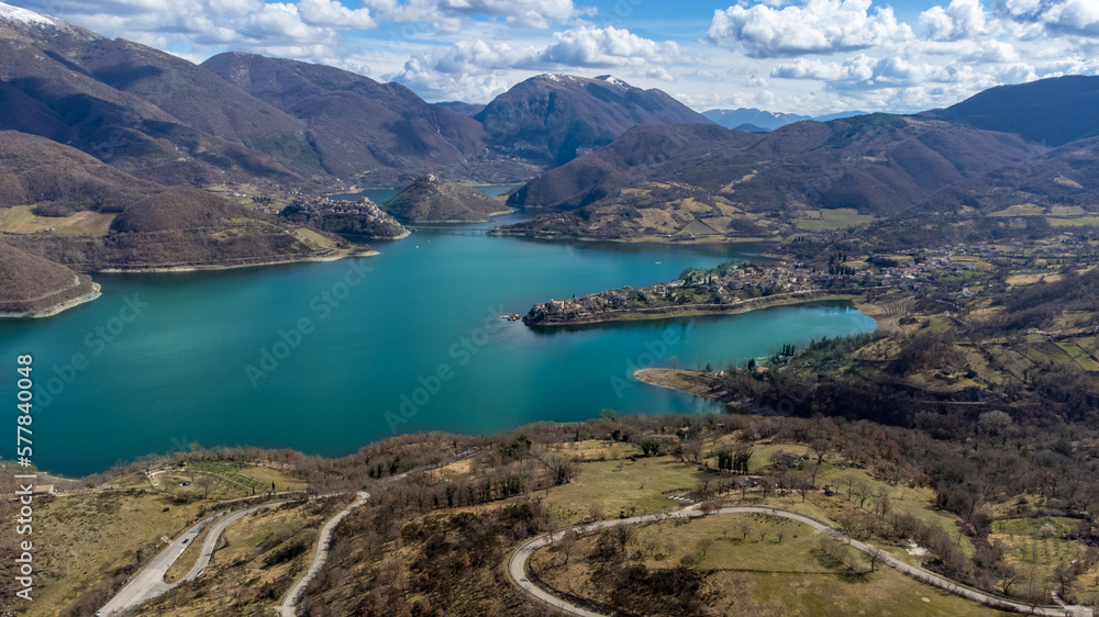 Panoramic aerial view of Turano lake. Lake with emerald water, winter landscape with perched town. Connecting bridge over the water