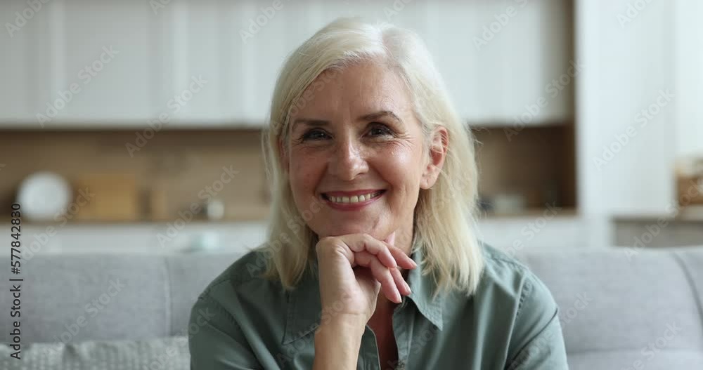 Head shot close up portrait happy older woman pose smile look at camera resting indoor, having attractive appearance, optimistic mood enjoy retired life, spend leisure at home. Midlife, natural beauty Head shot close up portrait happy older woman pose smile look at camera resting indoor, having attractive appearance, optimistic mood enjoy retired life, spend leisure at home. Midlife, natural beauty