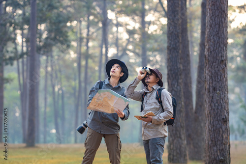 Team of the Asian naturalist looking at the map while exploring in the pine forest for surveying and discovering the rare biological diversity and ecologist on the field study concept