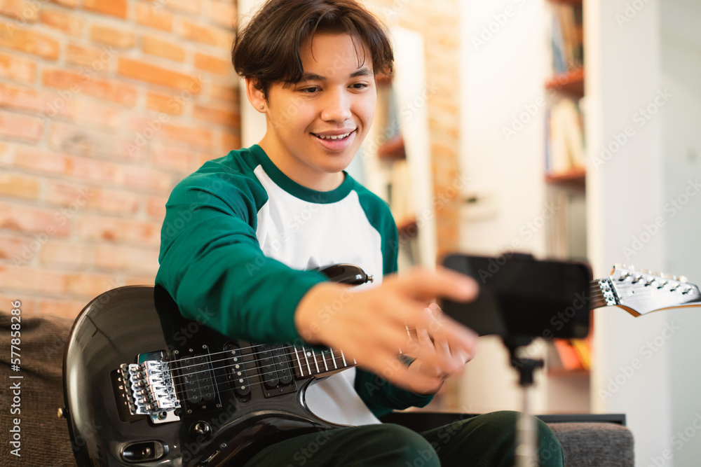 Korean Teen Boy Playing Guitar Shooting Video On Smartphone Indoors Korean Teen Boy Playing Guitar Shooting Video On Smartphone Indoors