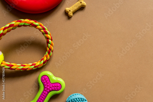 Frame with dogs rubber and textile toys, snacks, bones on orange background. Close up. Accessories for dogs 