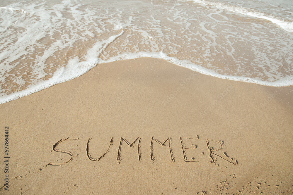 Fototapeta premium Summer 2023 lettering on the beach with wave and clear blue sea. 
