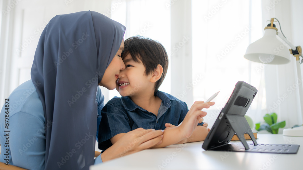 Mother and son reading E-book and teaching for painting using application together at home.