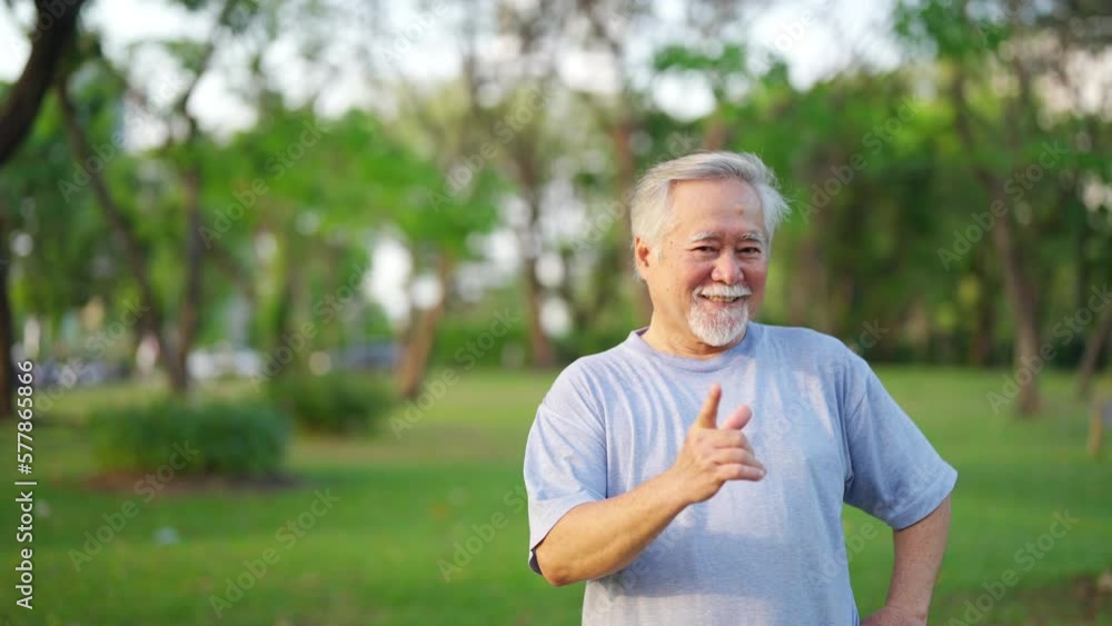 Portrait of Elderly Asian man in sportswear jogging exercise at park in the morning. Retired man enjoy outdoor lifestyle sport training workout running in the city. Senior person health care concept. Portrait of Elderly Asian man in sportswear jogging exercise at park in the morning. Retired man enjoy outdoor lifestyle sport training workout running in the city. Senior person health care concept.