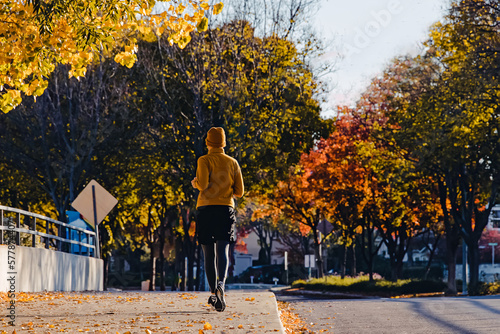 View from the back of man jogging outdoors in the fall. photo