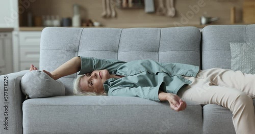 Overloaded powerless mature woman come back home and flopped down on sofa in living room feels without energy and too exhausted, squeezed like lemon after long hard working day. Rest, lack of strength