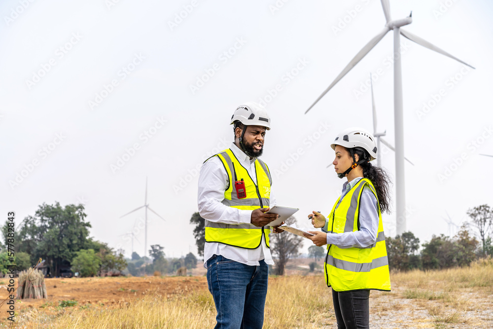 African american man and woman engineers in uniform discuss and use tablet working stand near wind turbines ecological energy industry, Environmental friendly for the future African american man and woman engineers in uniform discuss and use tablet working stand near wind turbines ecological energy industry, Environmental friendly for the future