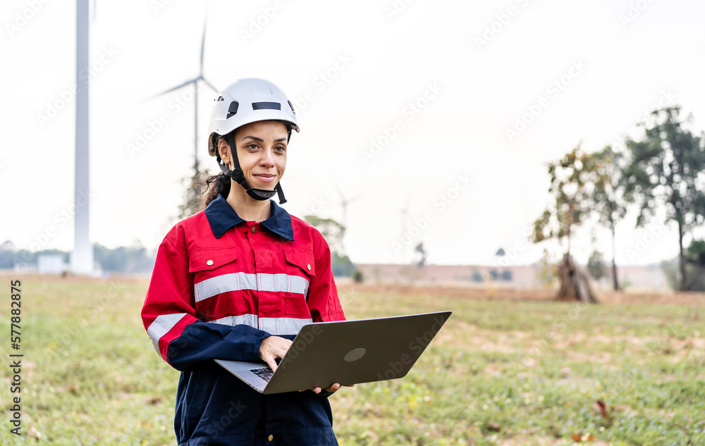 Black african american woman engineer in uniform using laptop working stand near wind turbines farm, ecological energy industry, Environmental friendly for the future Black african american woman engineer in uniform using laptop working stand near wind turbines farm, ecological energy industry, Environmental friendly for the future