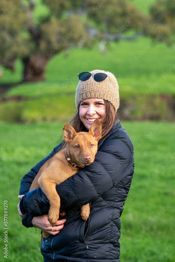 girl on a farm holding a puppy dog in her arms, tan kelpie puppy girl on a farm holding a puppy dog in her arms, tan kelpie puppy