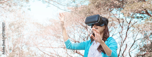 young asian girl using vr headset for relax in garden. For banner design.