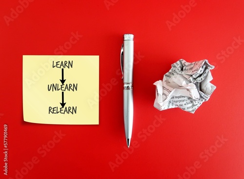 фотографія Pen, crumpled paper and note paper on red background with handwritten text Learn