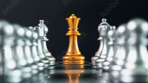 Gold chess piece stand on board and gray chess around black background for business concept.