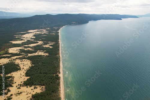 Barguzinsky Bay of Lake Baikal from the air. Waves on the lake, wildlife, sandy beach surrounded by coniferous forest. The Republic of Buryatia. photo