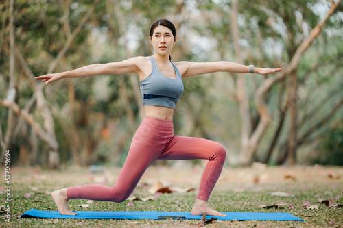 Portrait of young woman practicing yoga in garden.female happiness.  in the park blurred background. Healthy lifestyle and relaxation concept. © Nuttapong punna