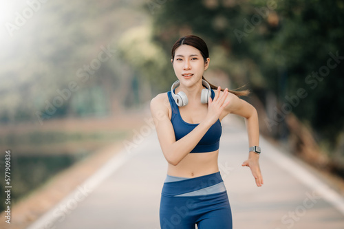 Young sporty woman running in green park.Sport lifestyle. Motion blur. in sun light © Nuttapong punna