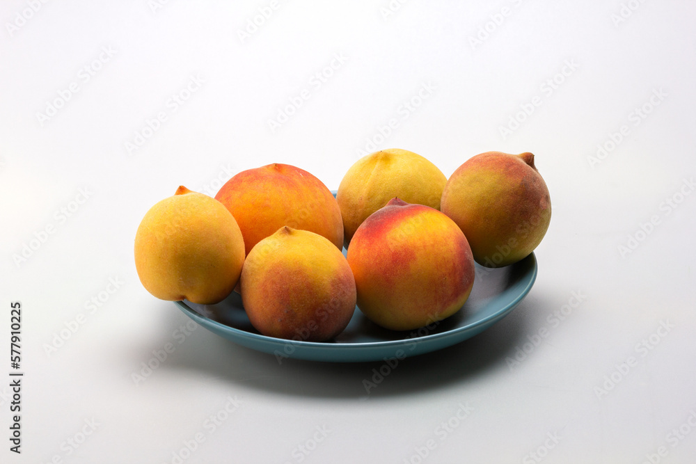 Fruits of ripe peaches on a dessert plate on a light background, close-up. Fruits of ripe peaches on a dessert plate on a light background, close-up.
