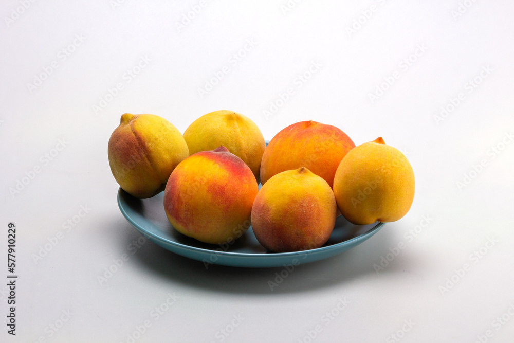 Fruits of ripe peaches on a dessert plate on a light background, close-up. Fruits of ripe peaches on a dessert plate on a light background, close-up.