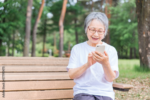 Stampa su tela 公園でスマホを使う高齢者女性（アプリ・操作・検索・写真・カメラ）