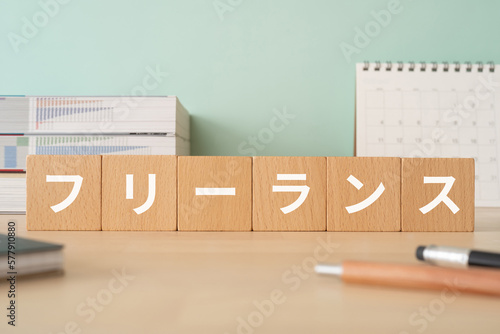 フリーランスと書かれたブロックが置かれたデスク
