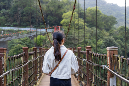 Woman crossing the suspension bridge in wulai of Taiwan