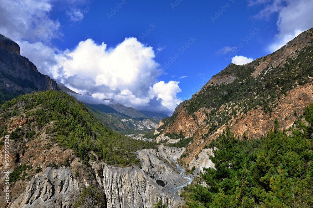 Obraz premium View of the Marshyangdi (Marsyangdi) River valley. Rocky valley of the Marshyangdi river with blue sky in the background on the way from Lower Pissang to Manang, Nepal, Asia.