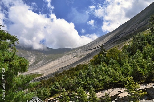 Paungda Danda, Annapurna Circuit Trek, Manang district, Nepal, Asia. View of the mountain with forest in the foreground and blue cloudy sky in the backgroud.  photo