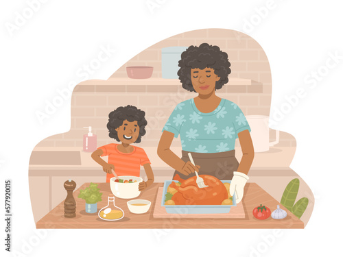 Beautiful African American woman cooks a turkey with her daughter who prepares a salad