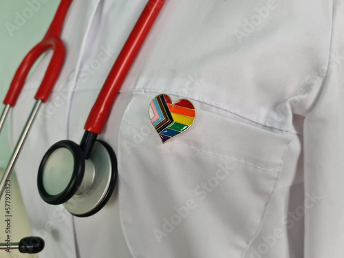 Silhouette of doctor in white coat with stethoscope and LGBT badge on pocket