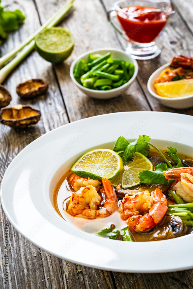 Thai seafood soup on wooden table
