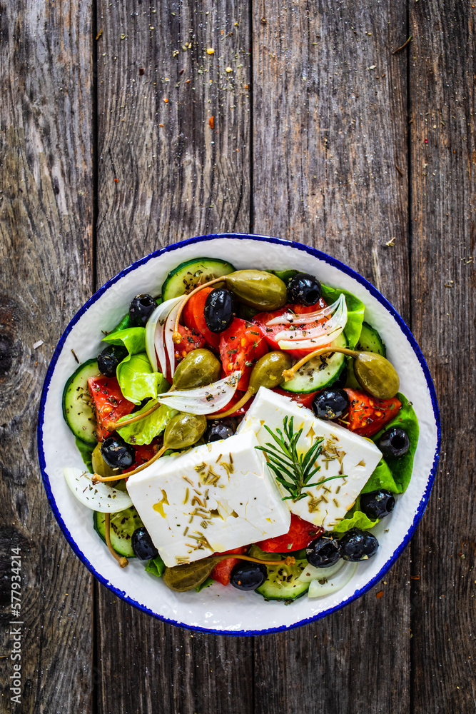 Fresh vegetable salad with feta cheese on wooden table
Fresh vegetable salad with feta cheese on wooden table