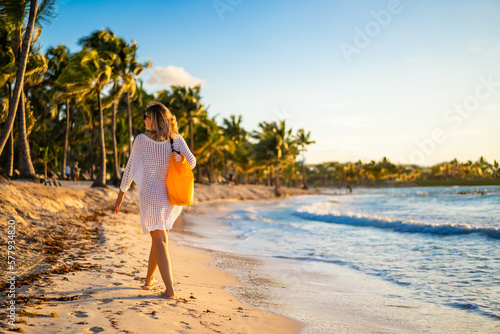Beach holiday - beautiful woman walking on sunny, tropical beach 
