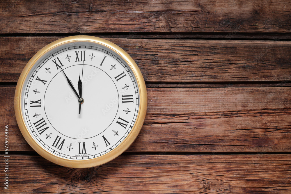 Clock showing five minutes until midnight on wooden table, top view with space for text. New Year countdown Clock showing five minutes until midnight on wooden table, top view with space for text. New Year countdown