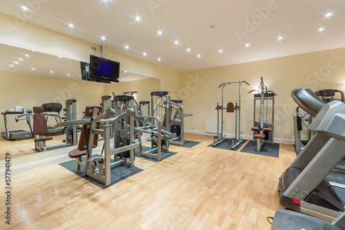 A modern gym in a private house with a variety of numerous sports equipment.