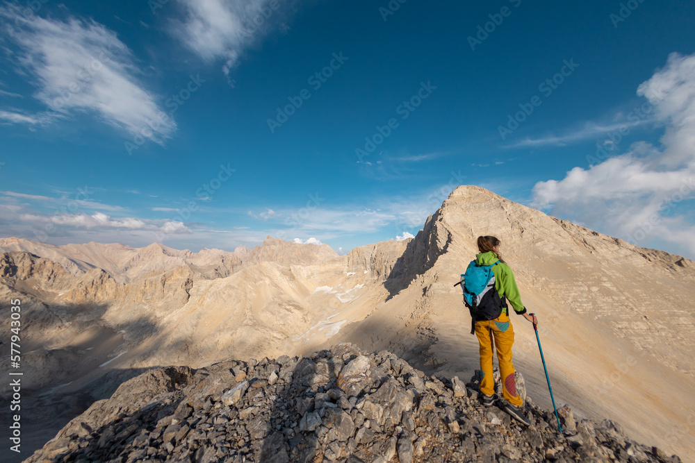 Hiking in the mountains. A girl with a backpack walks along a mountain path. Adventure climbing in the mountains.