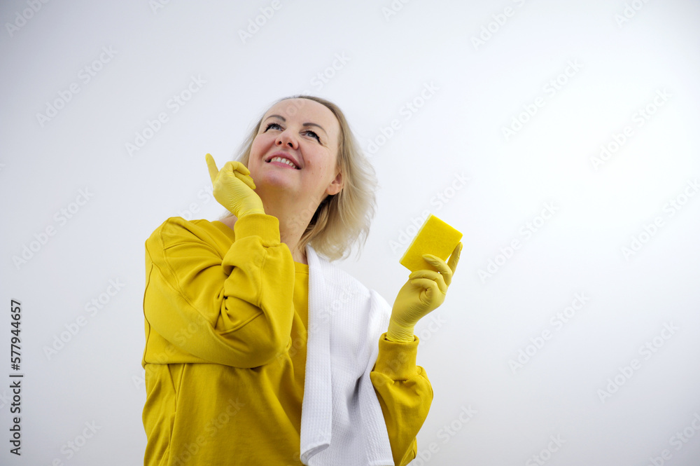 House cleaning cleaning company woman showing thumb up in yellow gloves in other hand she has sponge for washing dishes and windows of walls on shoulder white waffle towel advertising call to house House cleaning cleaning company woman showing thumb up in yellow gloves in other hand she has sponge for washing dishes and windows of walls on shoulder white waffle towel advertising call to house