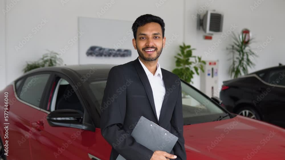 Portrait of a successful indian male manager in a car dealership, electric car sales Portrait of a successful indian male manager in a car dealership, electric car sales