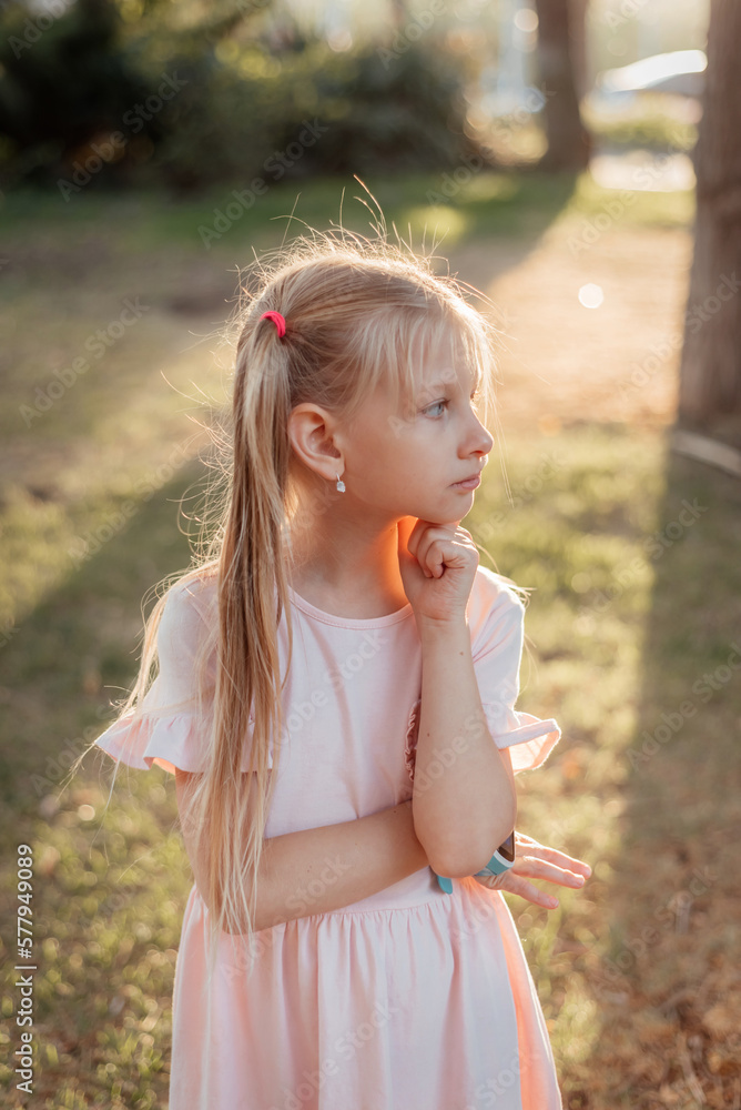 Girl with white hair in sunset light. Children's smart watch. Girl with white hair in sunset light. Children's smart watch.