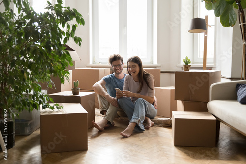 Foto Joyful dating couple moving in apartment together, enjoying relocation, sitting